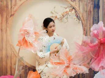 a woman in a kimono holding a fan