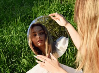 a woman looking at her reflection in a mirror