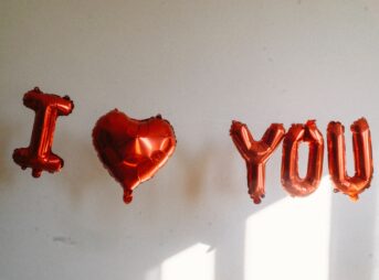 balloons spelling out i love you in front of a white wall