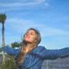 woman spreading arms near body of water