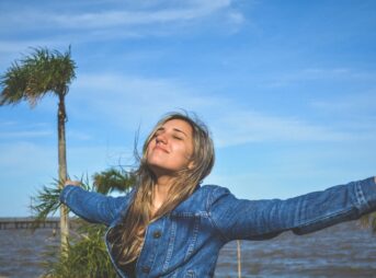 woman spreading arms near body of water