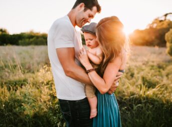 family photo on green grass during golden hour