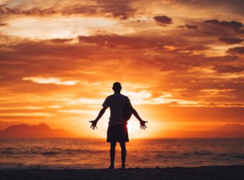 silhouette of man running on beach during sunset