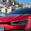 a red car parked in front of a city