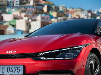 a red car parked in front of a city