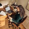 Woman working at a desk with laptop and tablet.